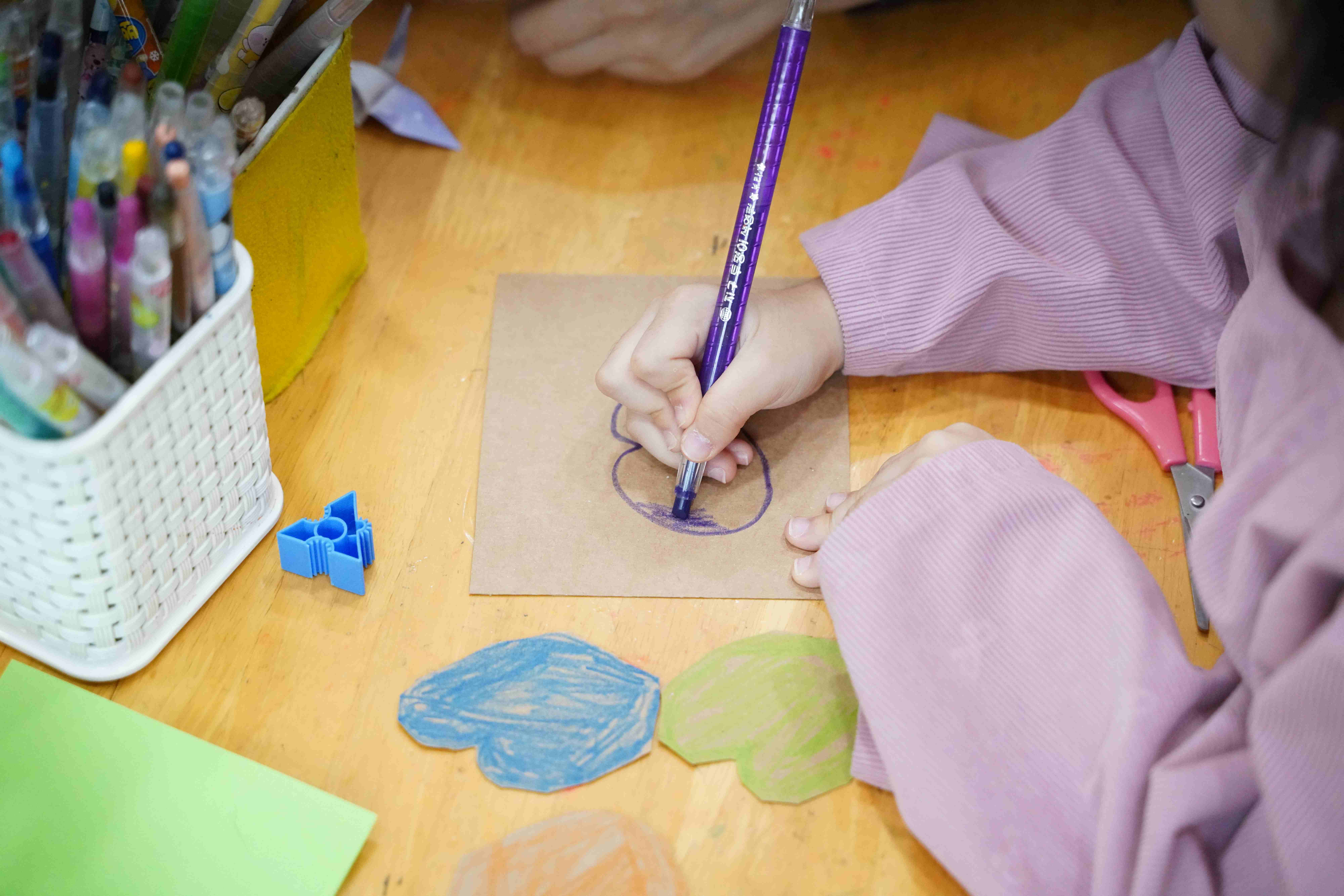 아이가 종이에 그림을 그리며 창의력을 발휘하는 모습