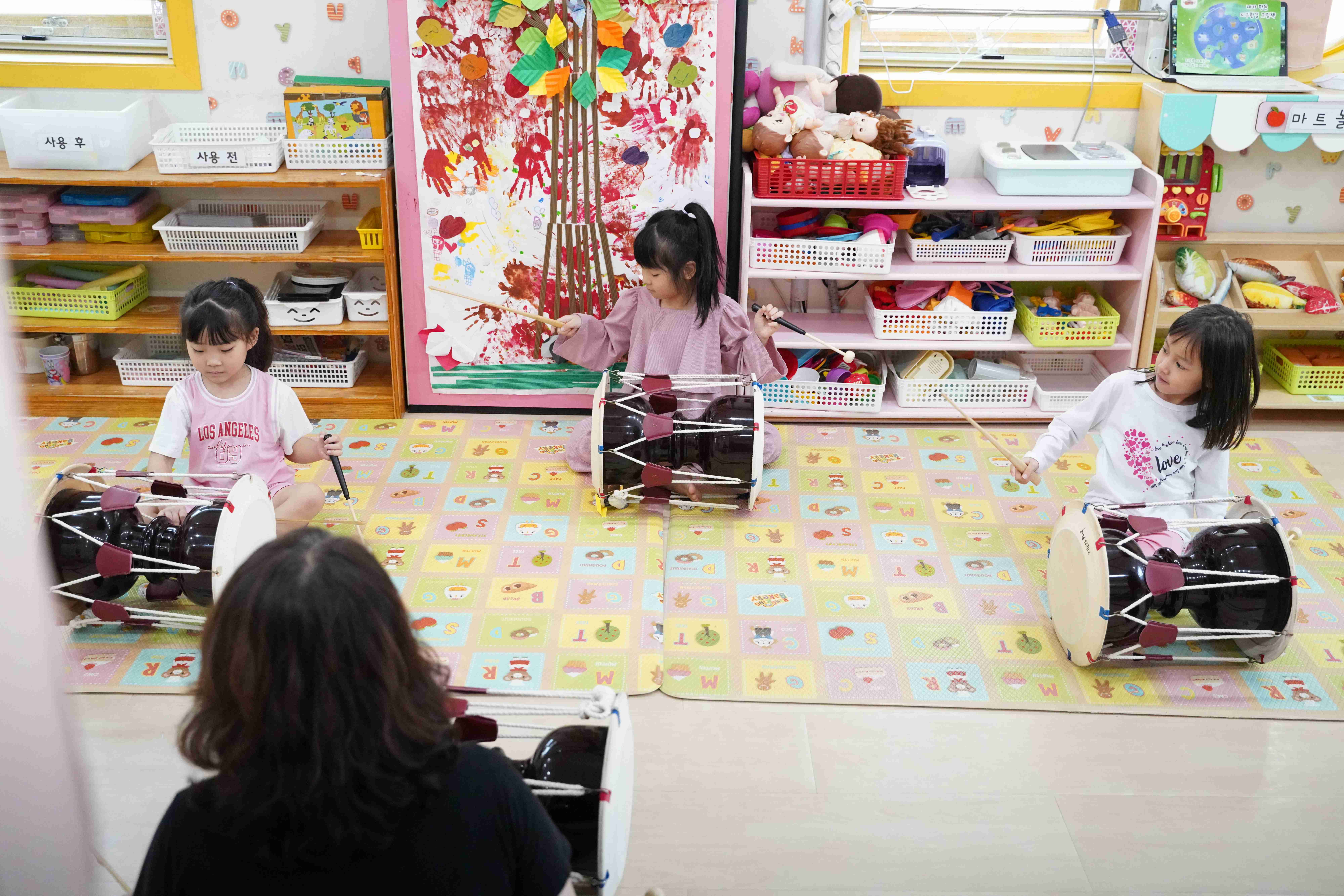 아이들이 장구를 치며 전통 음악을 배우는 모습